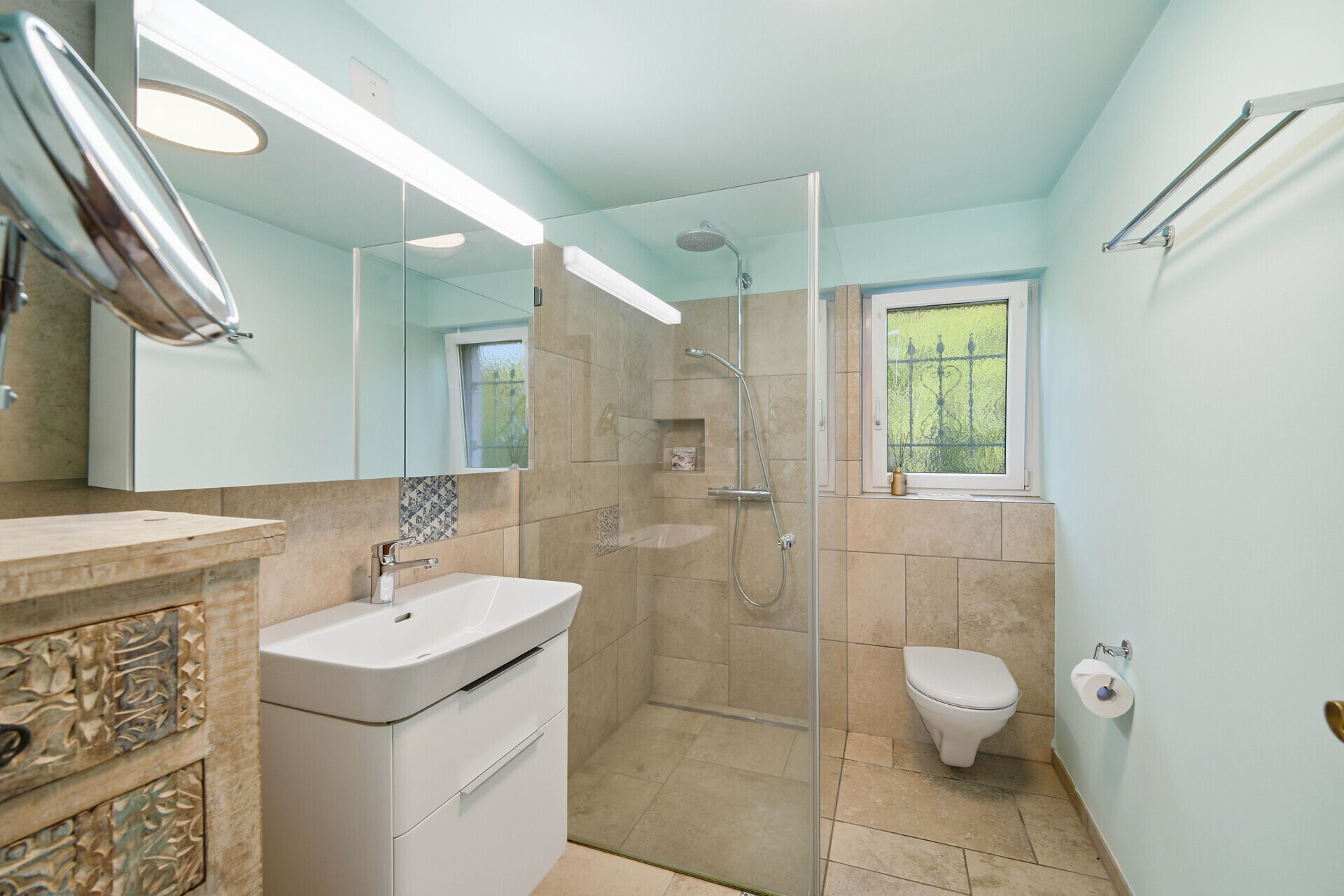 Helles Badezimmer mit begehbarer Dusche und Fenster