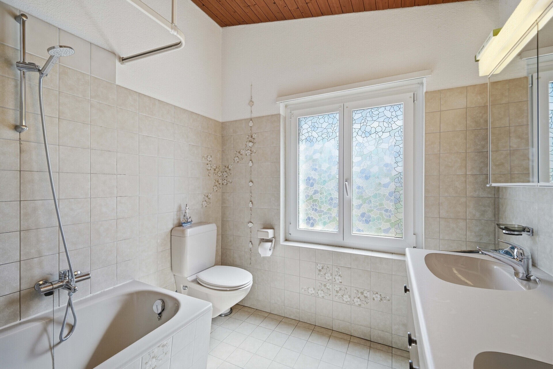 Badezimmer mit Badewanne, WC und Fenster