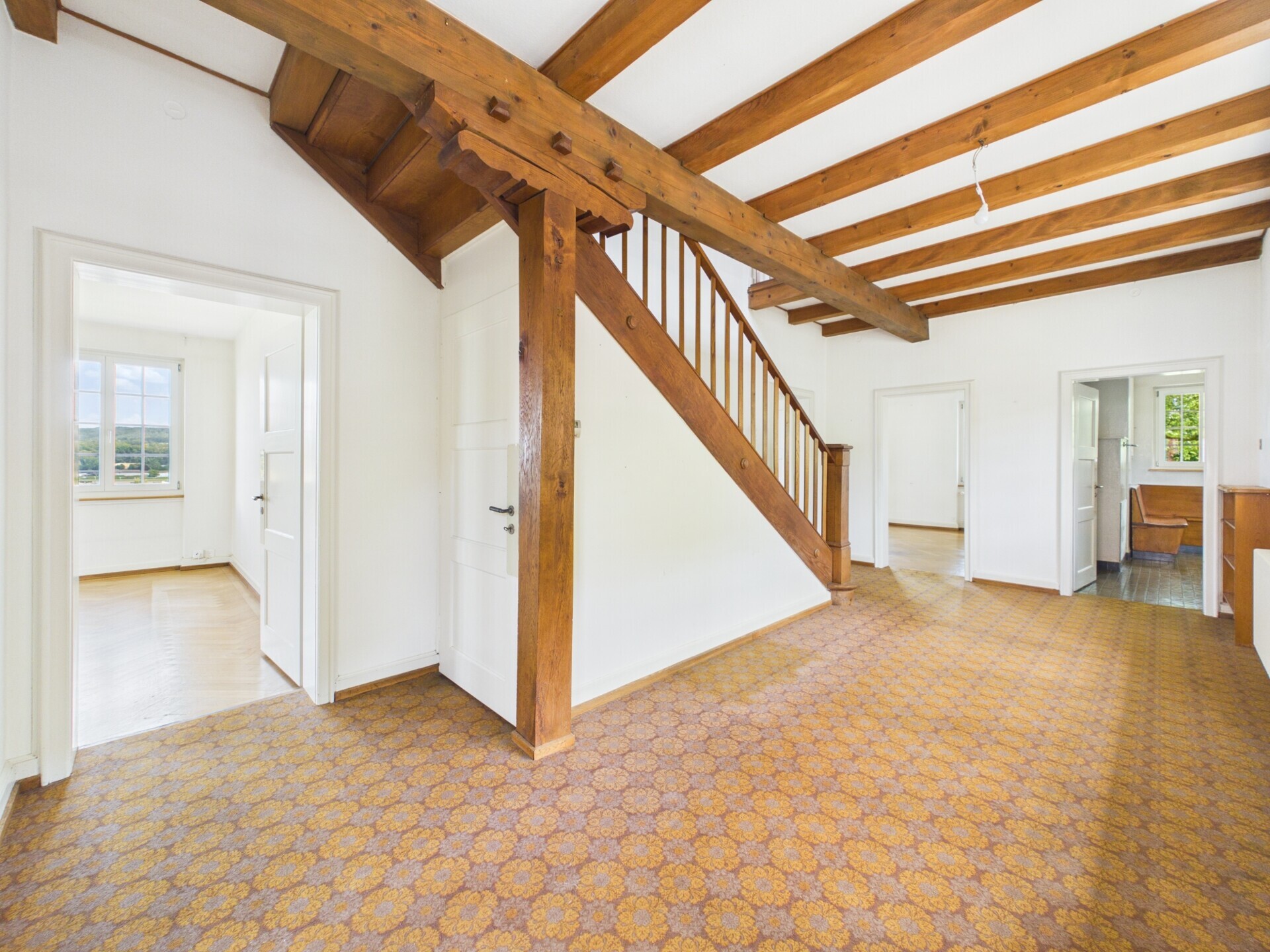Dachgeschossflur mit Holzbalken und Treppe