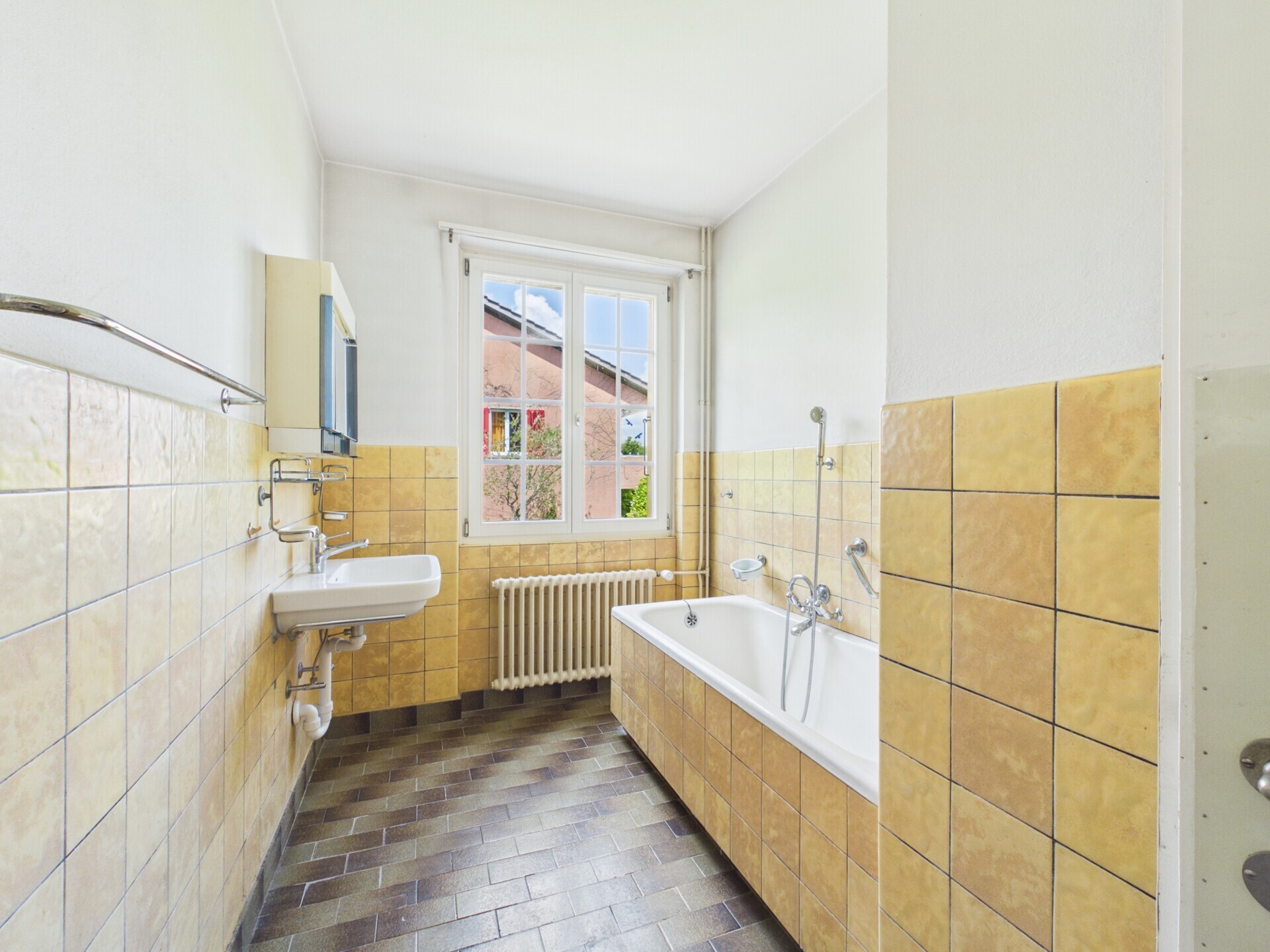 Schmales Badezimmer mit Badewanne und Fenster