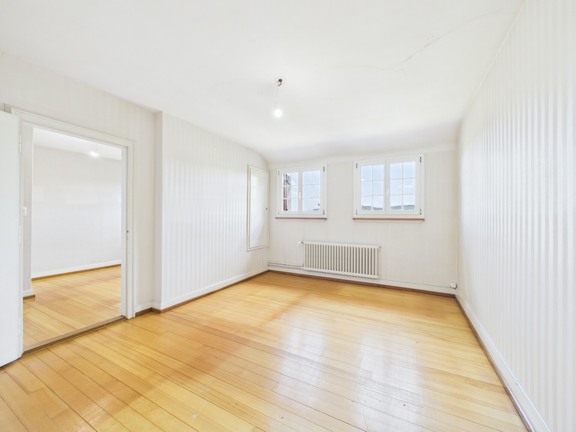 Helles, leeres Zimmer mit Holzboden