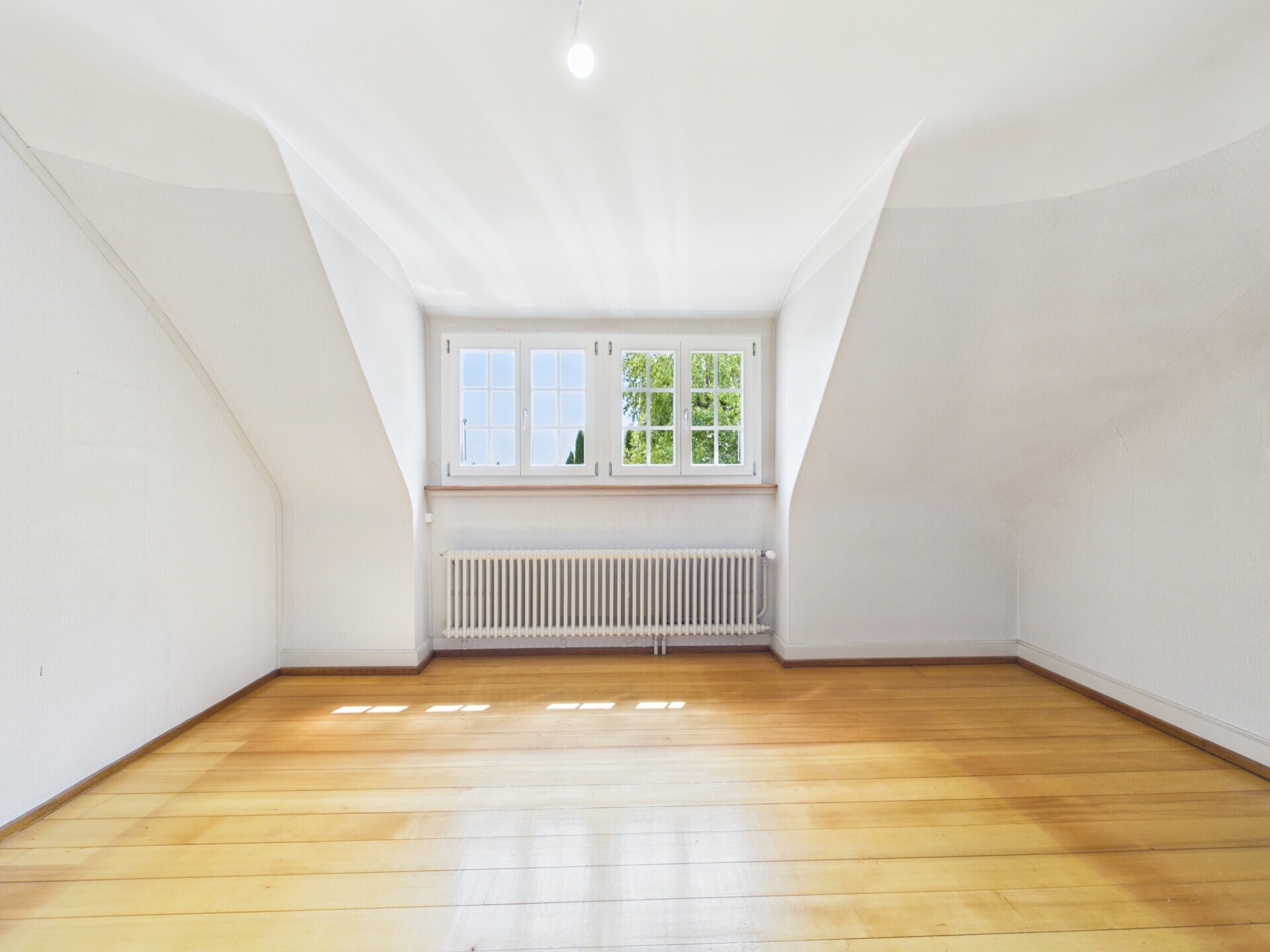 Heller leerer Dachraum mit Fenster und Heizkörper
