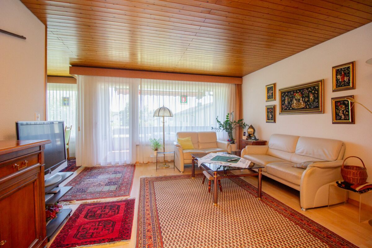 Wohnzimmer mit Holzdecke und großen Vorhängen