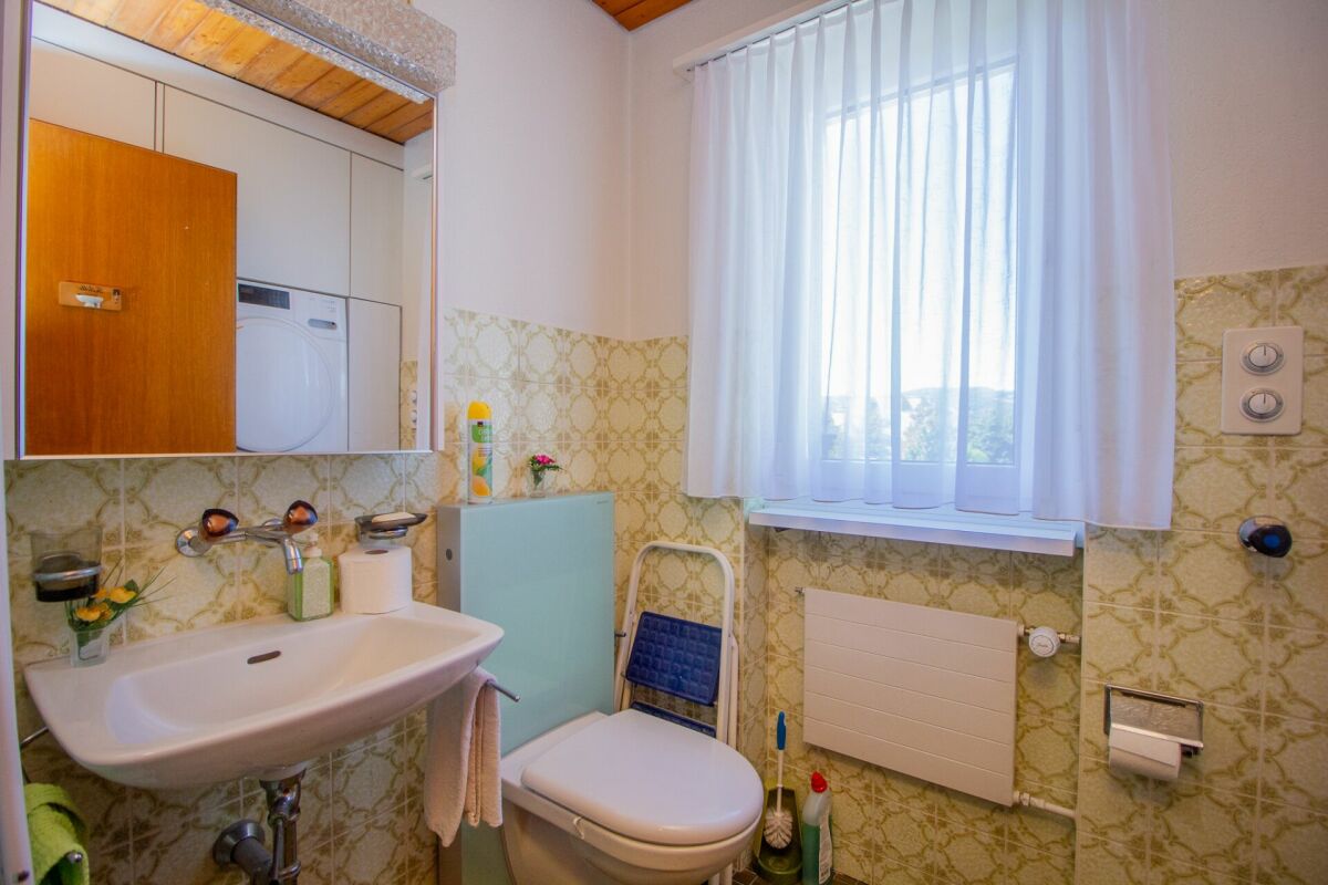 Kleines Badezimmer mit Waschmaschine und Fenster