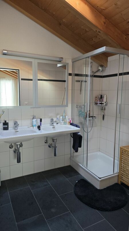Modernes Badezimmer mit Holzdecke und Glasdusche