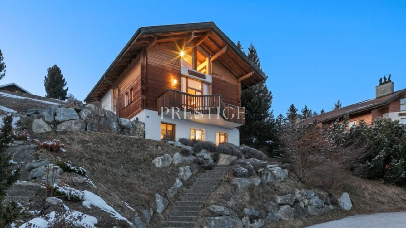 Alpines Chalet mit Balkon bei Dämmerung
