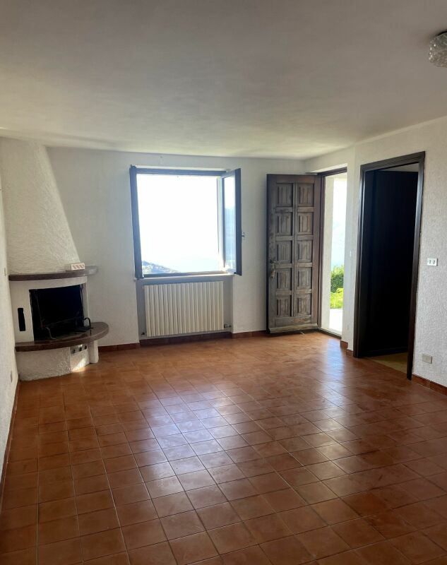 Leerer Wohnraum mit Kamin und Fenster