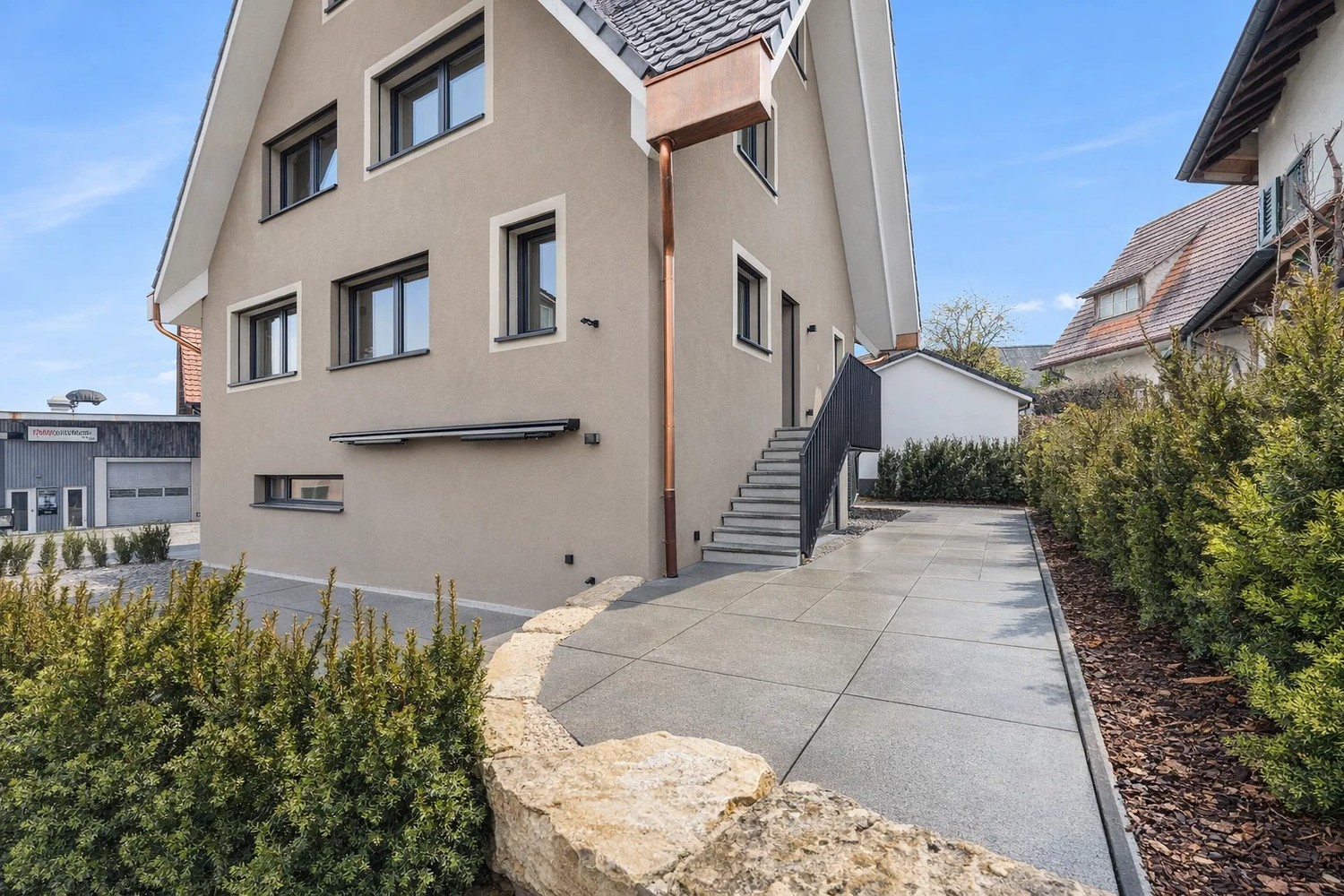 Außenansicht eines modernen Einfamilienhauses mit Zugangsweg