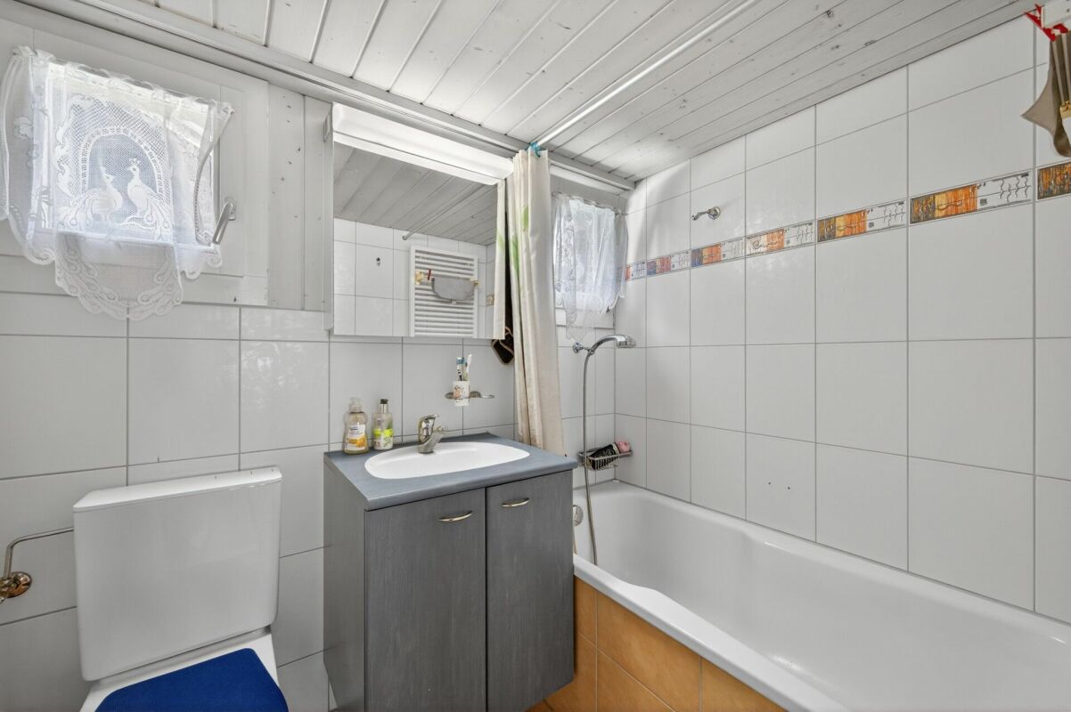 Kleines Badezimmer mit Badewanne und WC