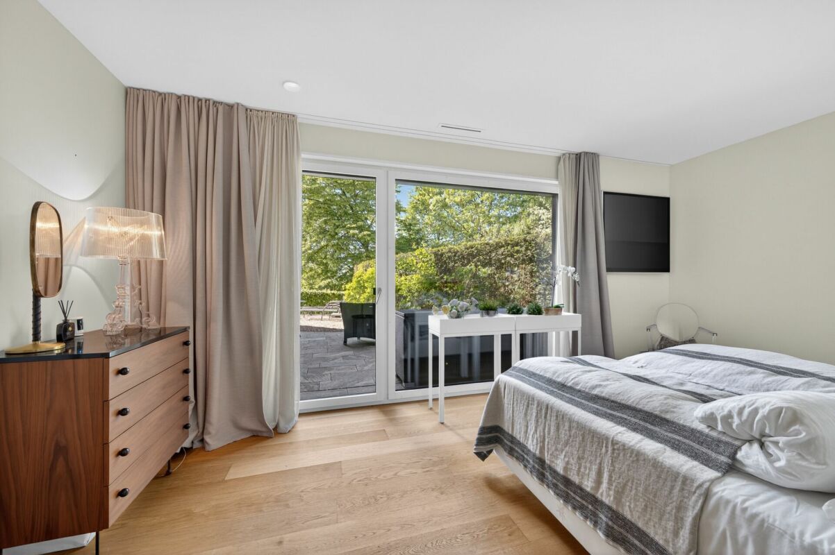 Hell eingerichtetes Schlafzimmer mit Gartenblick
