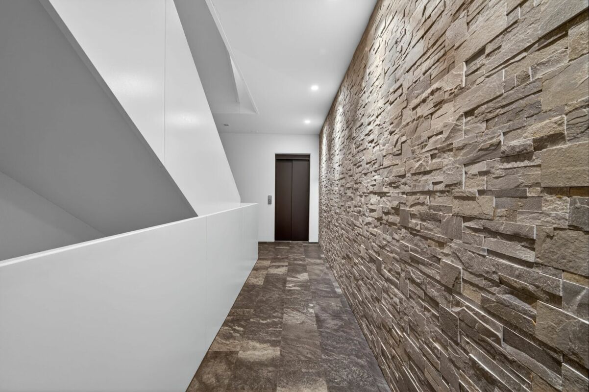 Moderner Flur mit Steinakzentwand