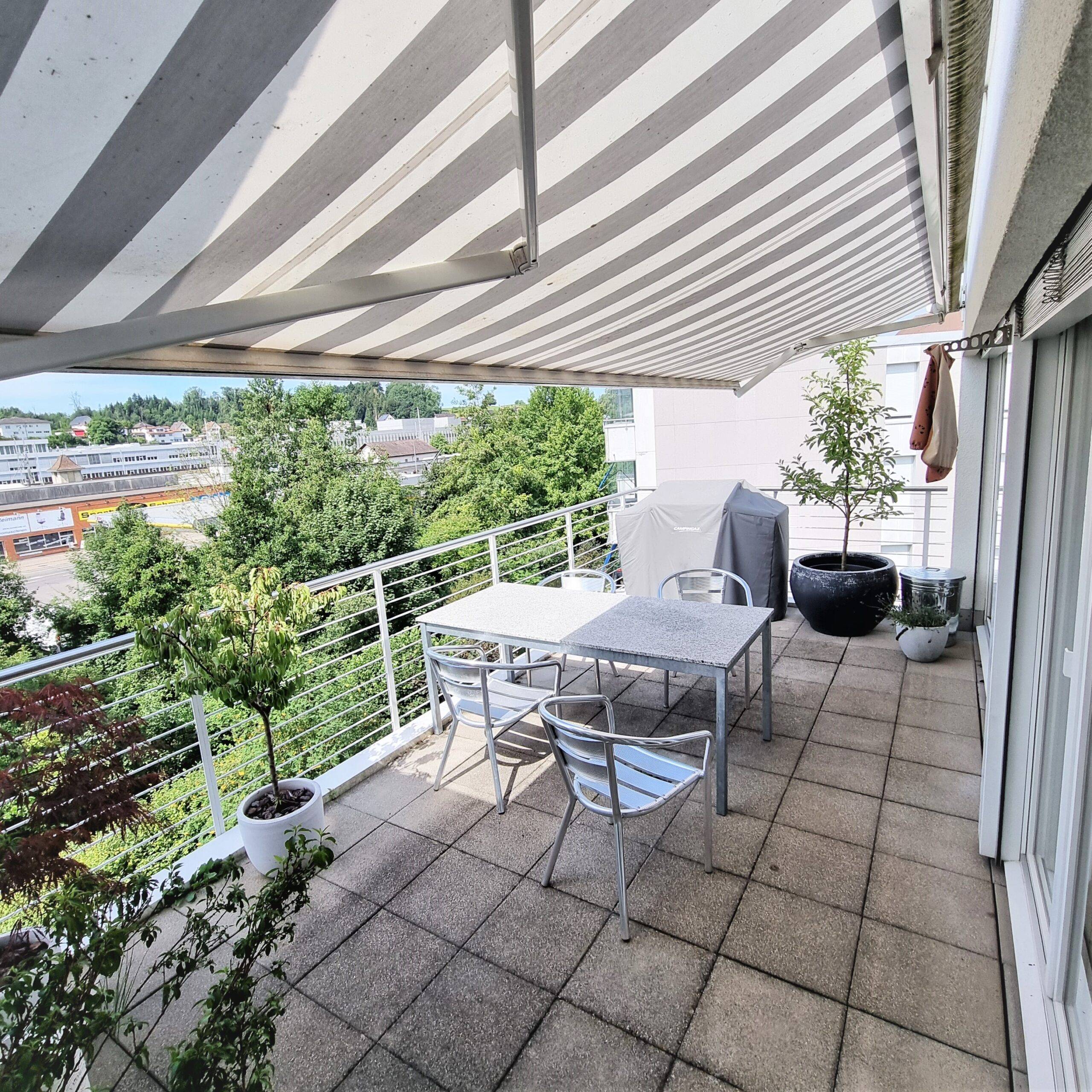Überdachter Balkon mit Sitzgruppe