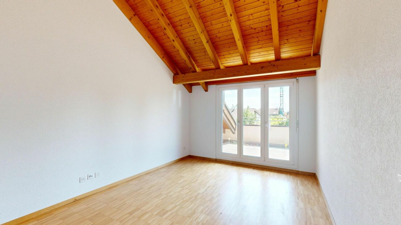 Heller Dachraum mit Holzbalkendecke und Balkonzugang