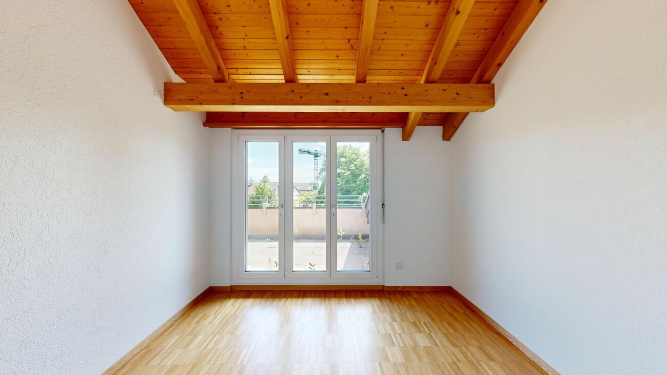 Heller Raum mit Holzdecke und Terrassentür
