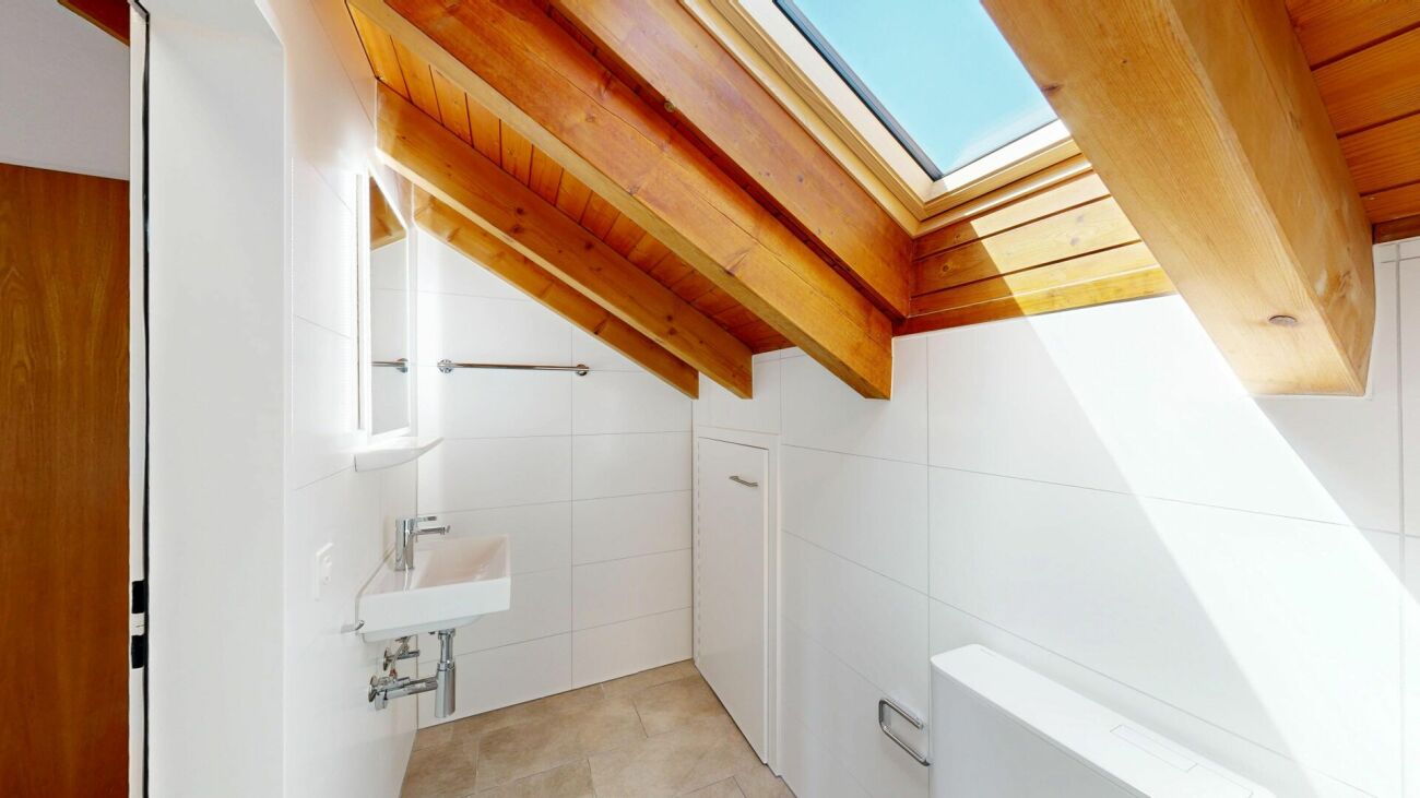 Helles Dachbad mit Holzdecke und Dachfenster