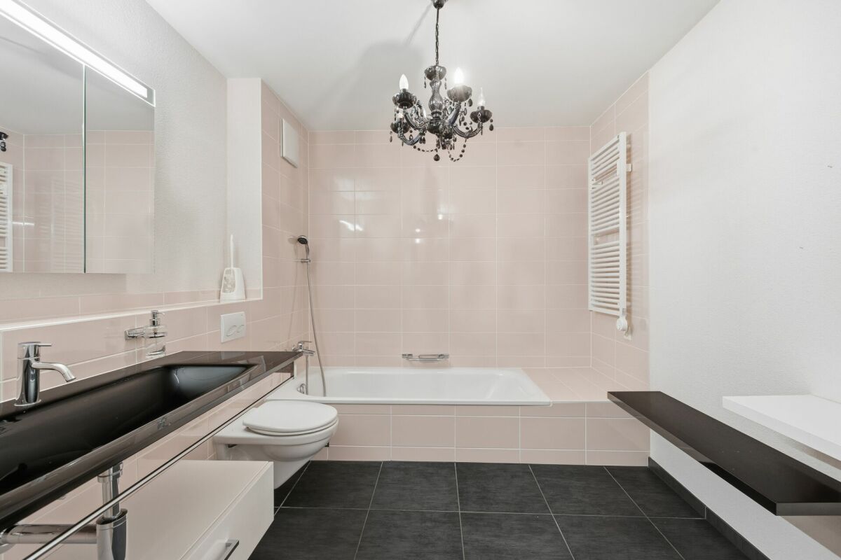 Helles Badezimmer mit Badewanne und Waschplatz