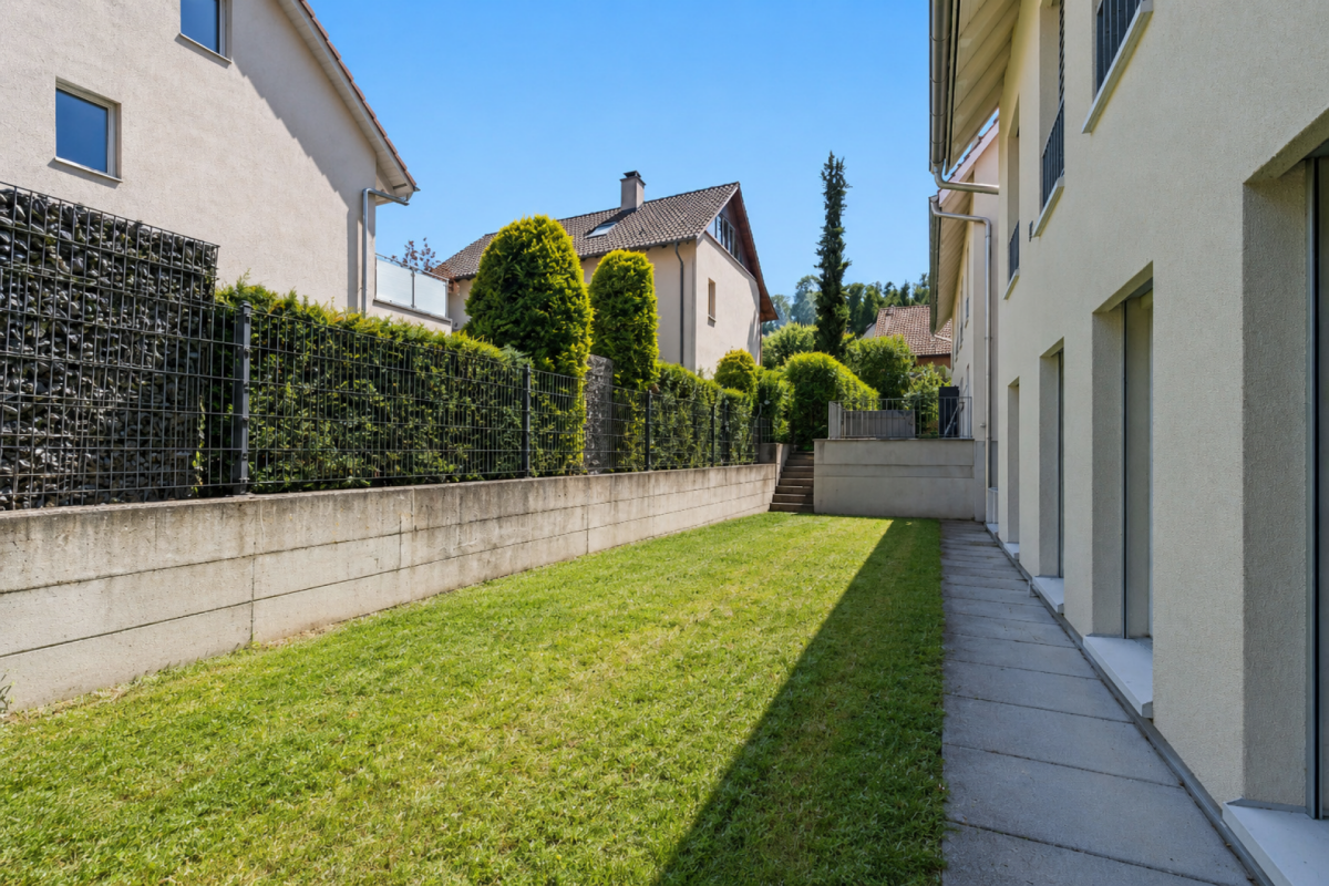 Gepflegter seitlicher Gartenbereich zwischen Wohnhäusern