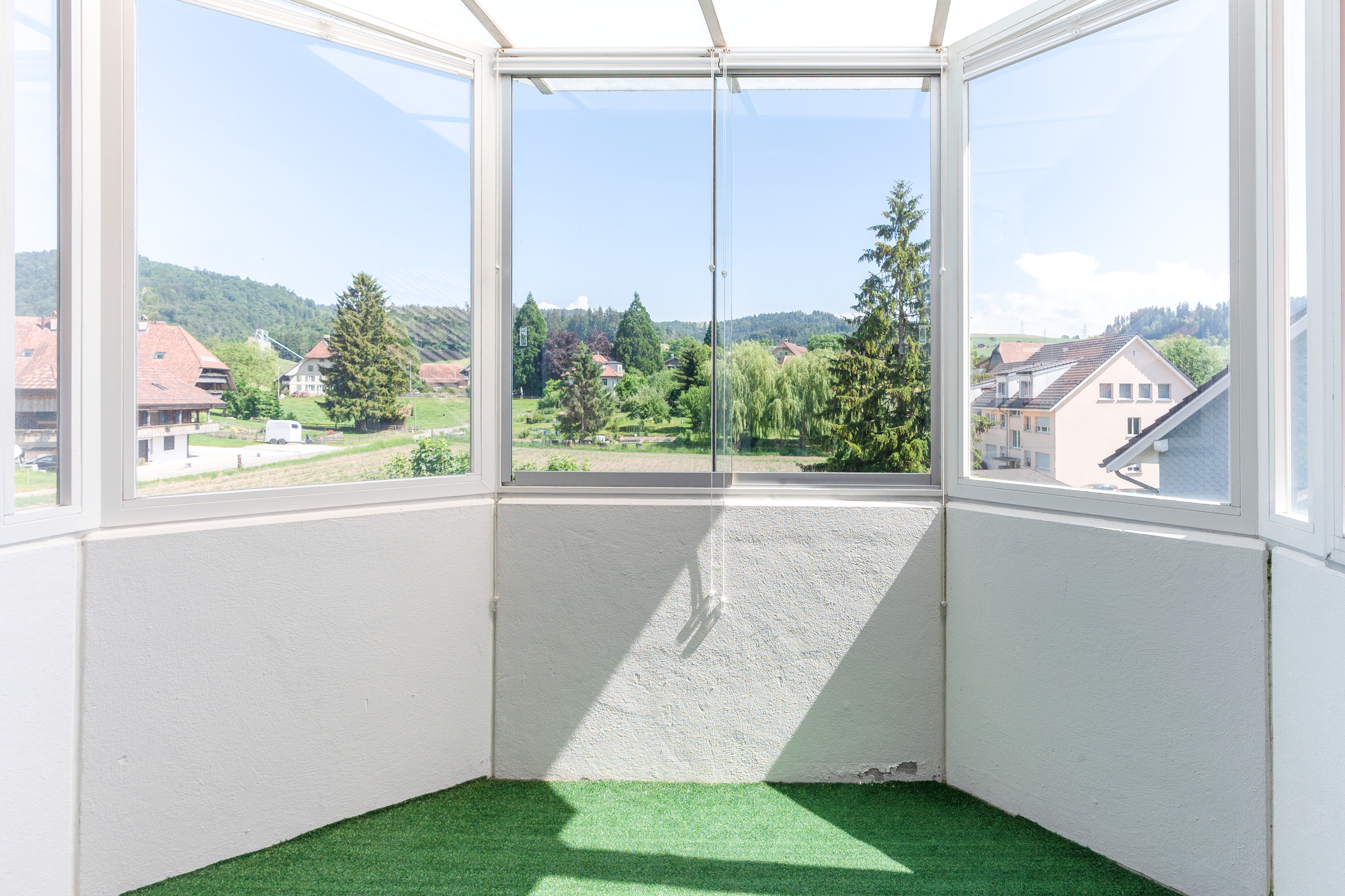Heller verglaster Balkon mit Aussicht ins Grüne