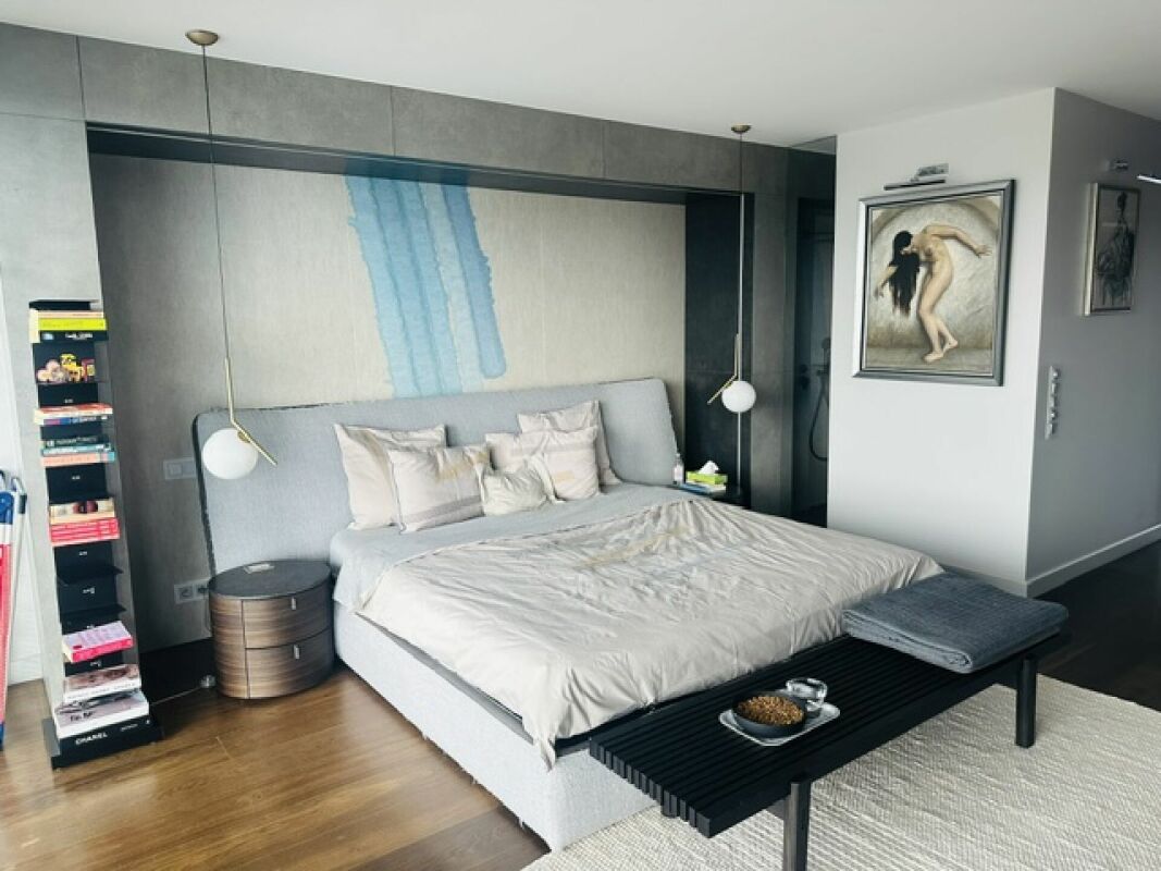 Modernes Schlafzimmer mit großem Bett und Kunstakzent