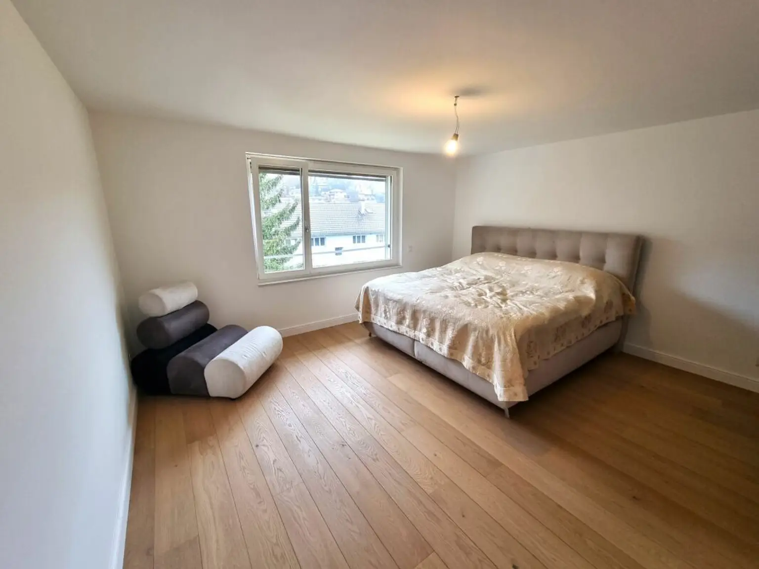 Helles Schlafzimmer mit Bett und Fenster