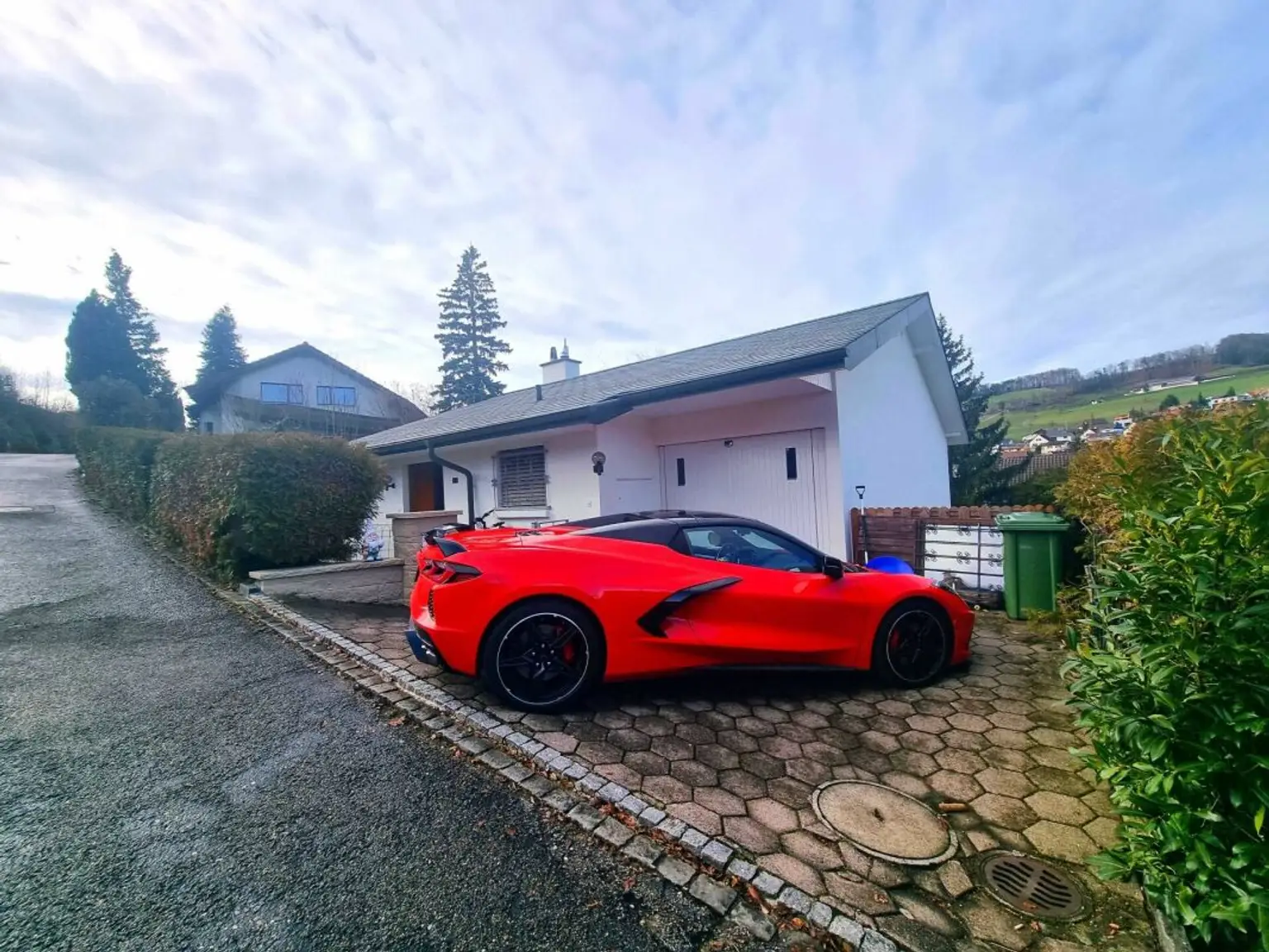 Modernes Haus mit rotem Sportwagen im Vorgarten