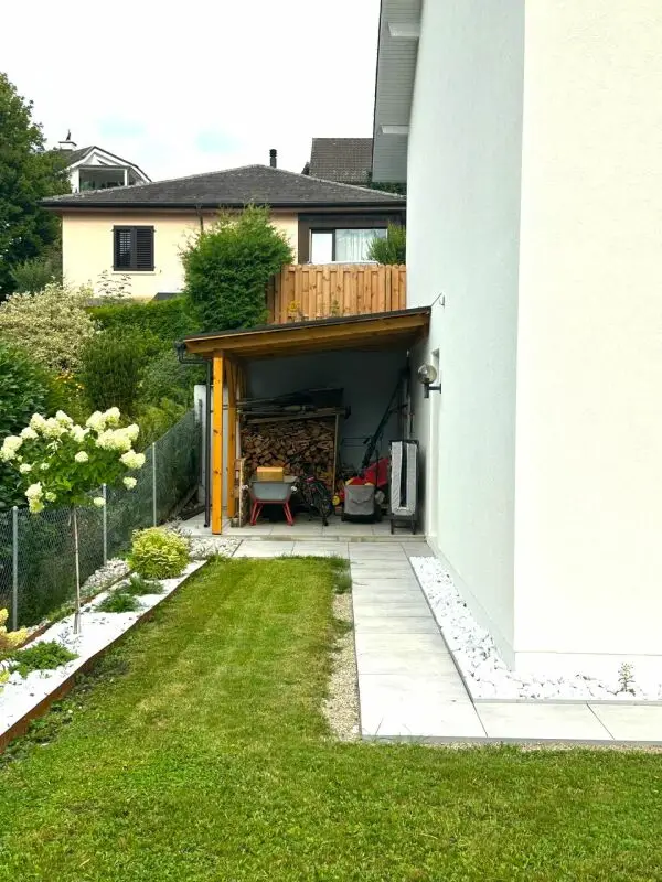 Garten mit Unterstand und seitlicher Hausansicht