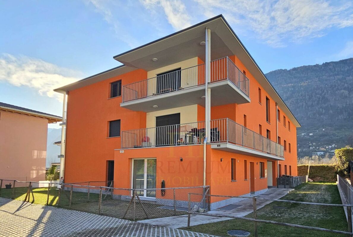 Mehrfamilienhaus mit orangefarbener Fassade und Balkonen