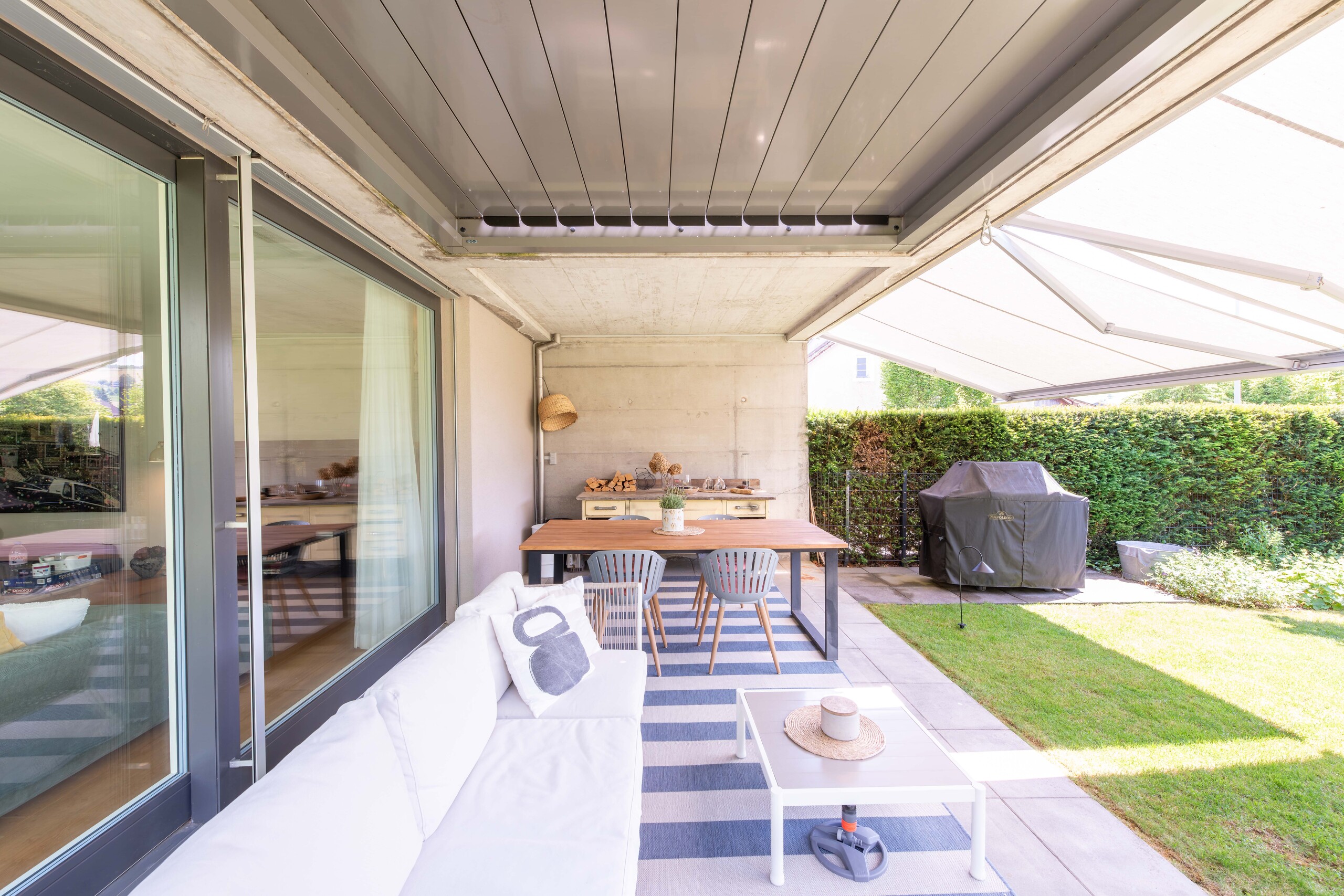 Überdachte Terrasse mit Ess- und Sitzbereich