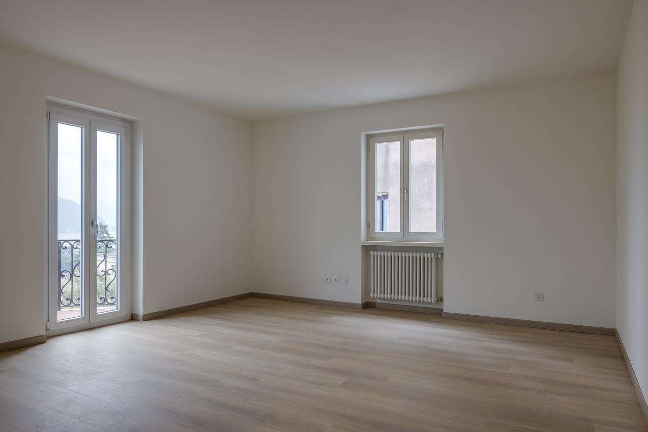 Leerer heller Wohnraum mit Balkon und Heizkörper