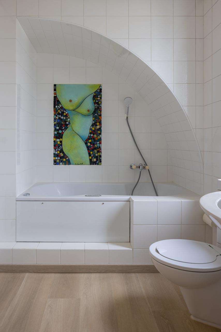 Badezimmer mit Badewanne und Wandkunst