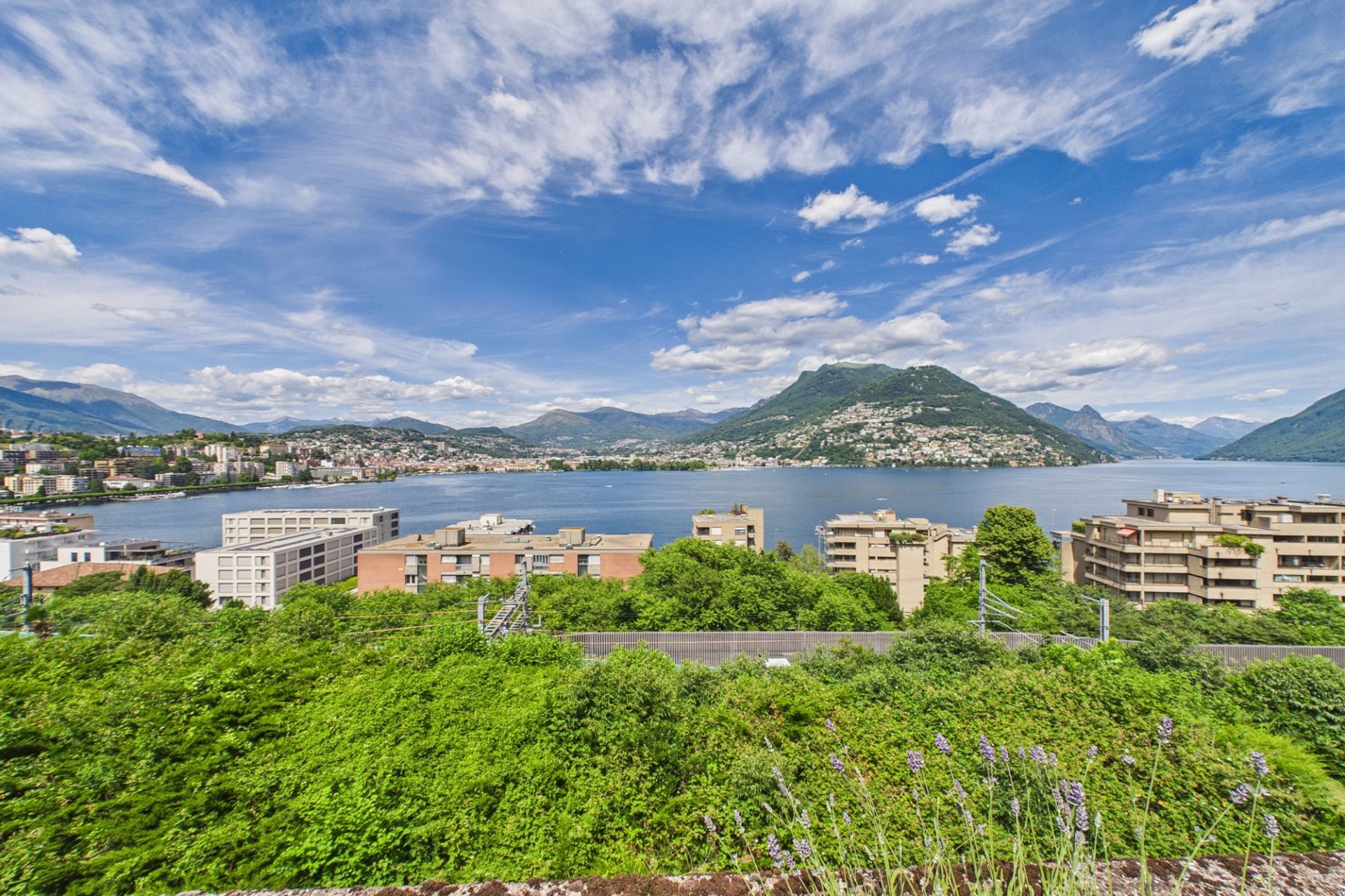 Seeblick mit Bergen und Stadtpanorama