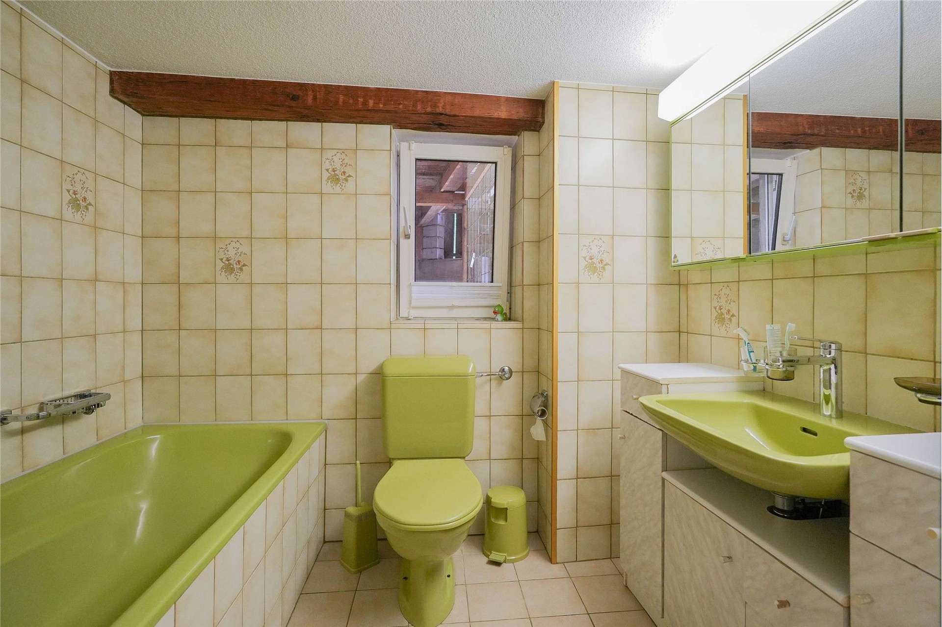Badezimmer mit Badewanne und grünem Sanitär