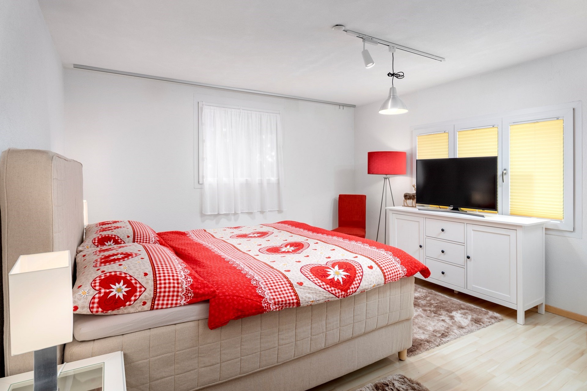 Helles Schlafzimmer mit roter Bettwäsche