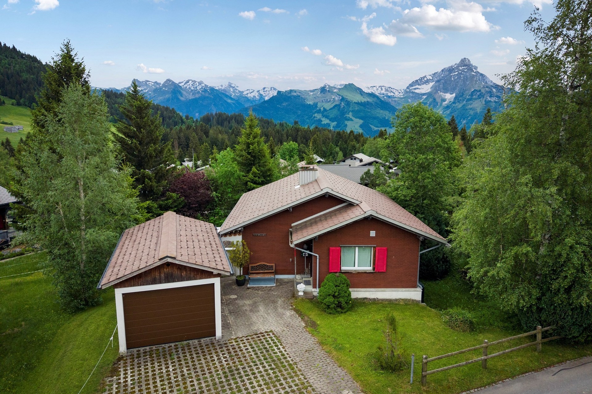 Alpine Haus mit Garagengebäude und Bergblick