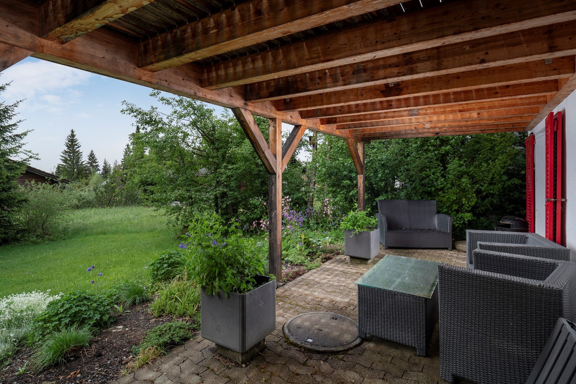 Überdachte Terrasse mit Gartenmöbeln