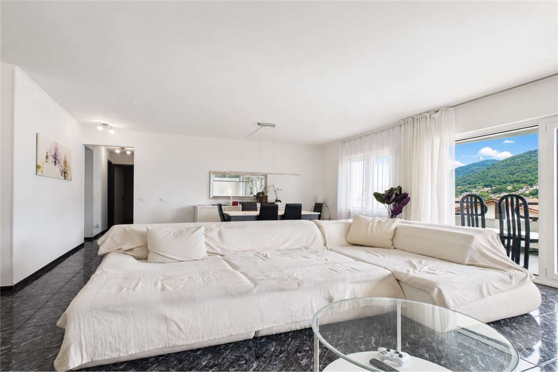 Heller Wohnraum mit großem Sofa und Ausblick