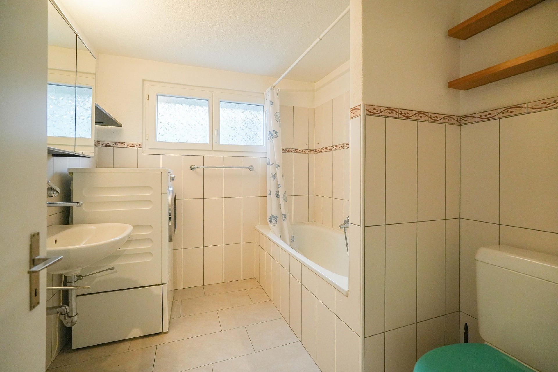Kleines Bad mit Wanne und Waschmaschine