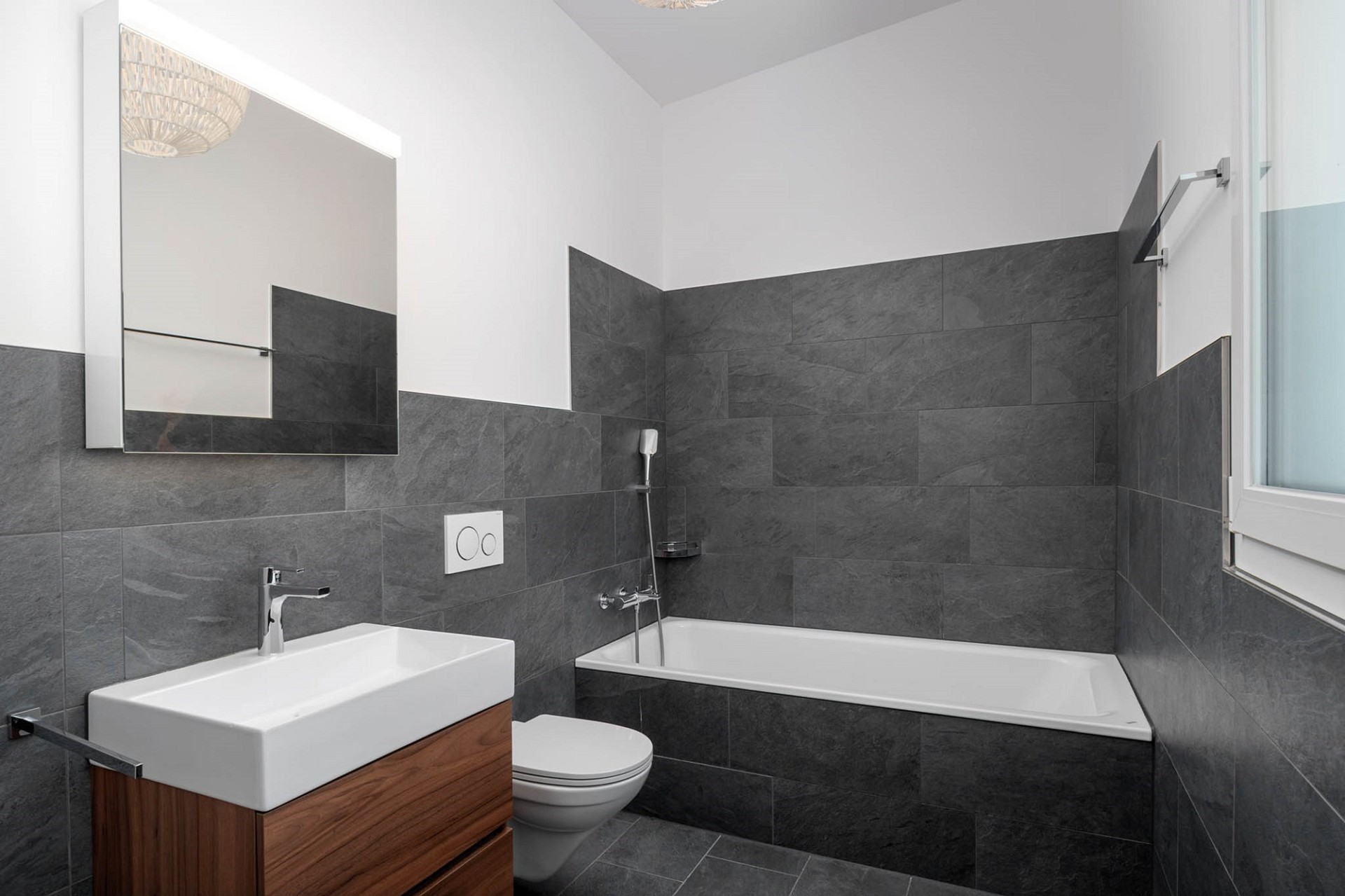 Modernes Badezimmer mit Badewanne, Waschtisch und WC