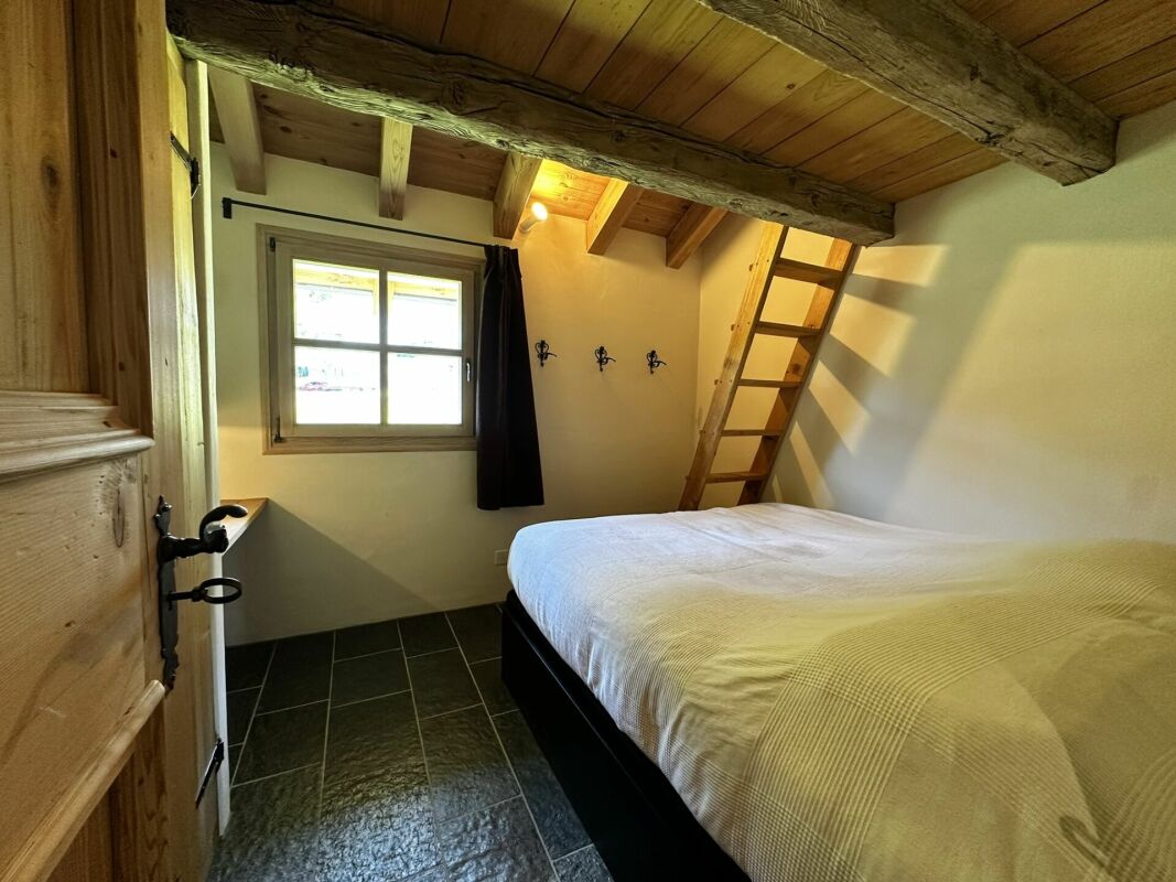 Kleines rustikales Schlafzimmer mit Holzbalken