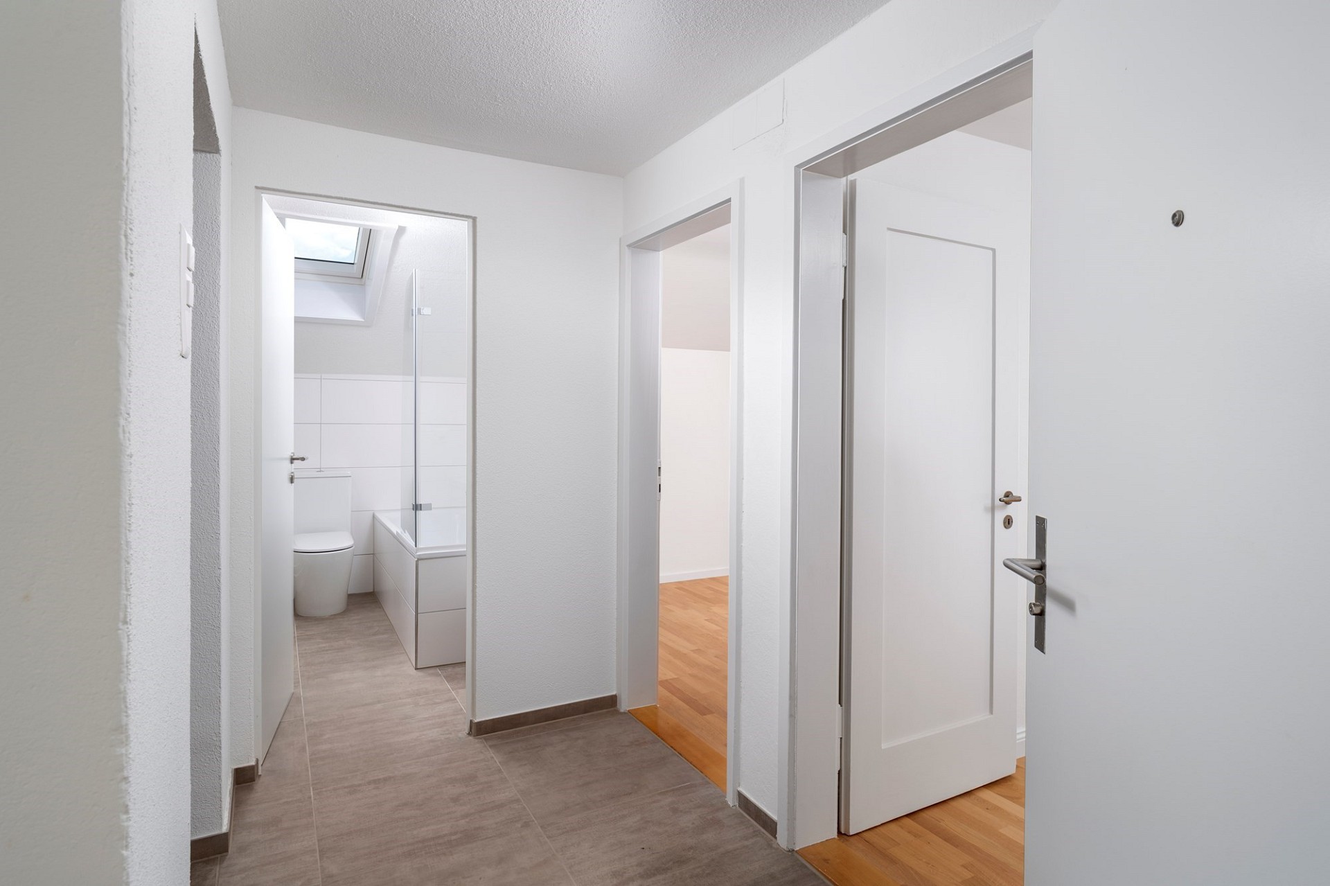 Heller Flur mit Blick in Bad und Zimmer