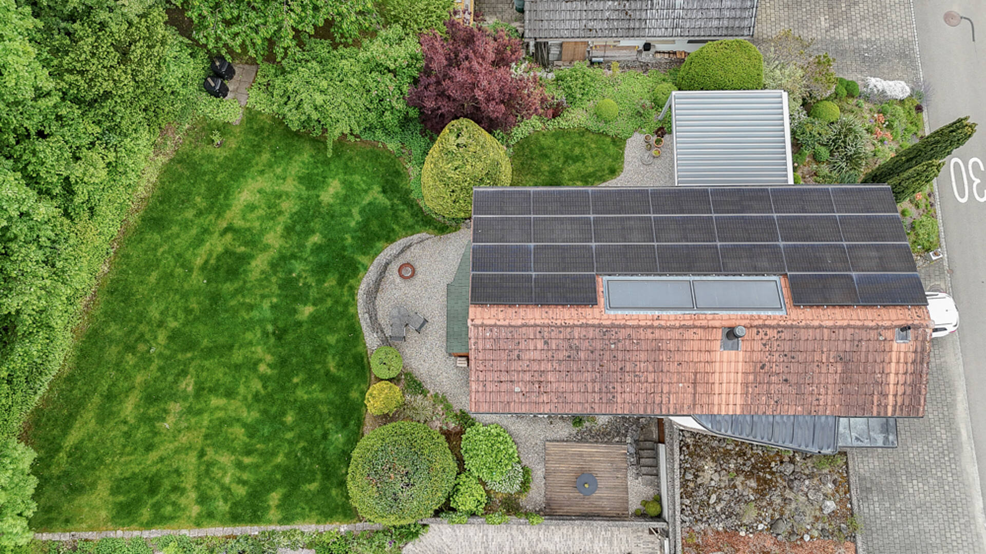 Drohnenaufnahme eines Wohnhauses mit großem Garten und Solardach