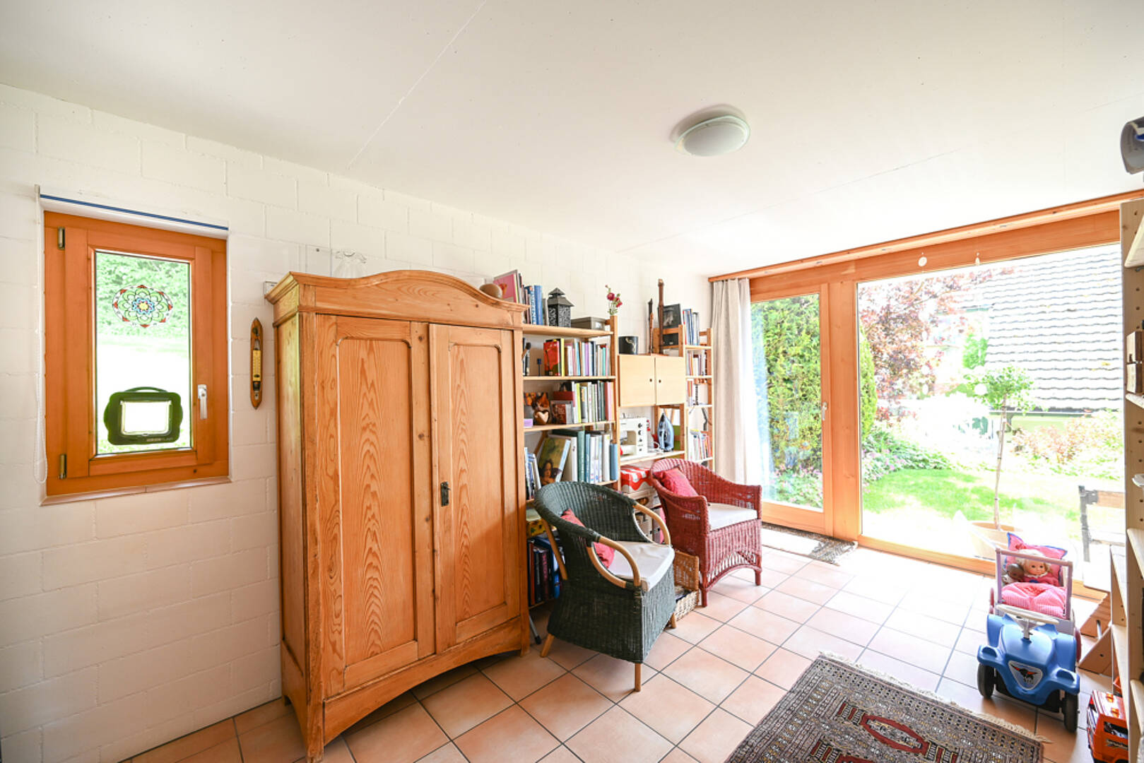 Heller Wohnraum mit Holzschrank und Gartenblick