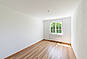 Heller leerer Raum mit Holzfußboden und Fenster