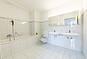 Helles Badezimmer mit Doppelwaschtisch und Badewanne