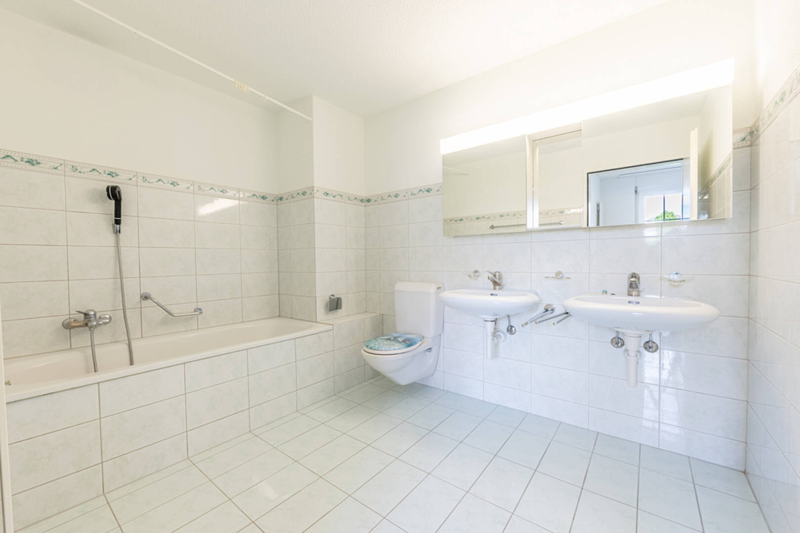 Helles Badezimmer mit Wanne, Doppelwaschbecken und WC