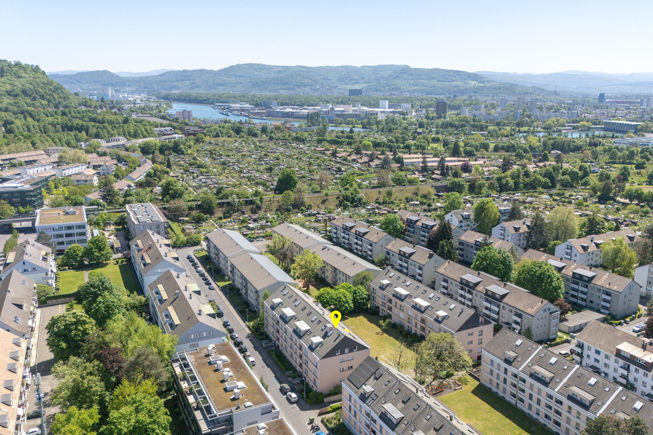 Luftaufnahme eines Wohngebiets am Fluss mit Hügelkulisse
