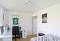 Helles Schlafzimmer mit Einzelbett und Stuhl