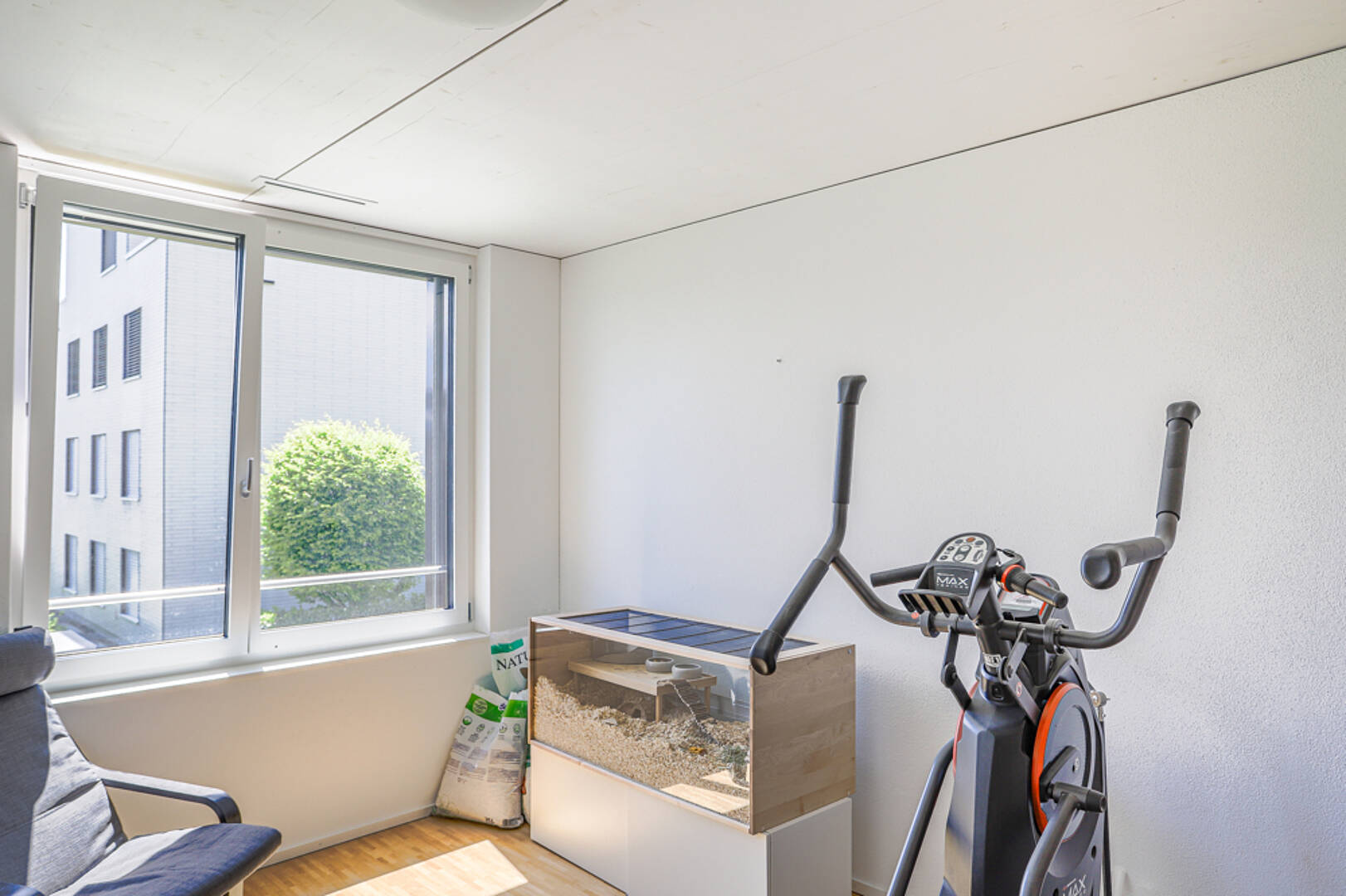 Heller kleiner Raum mit Fenster und Fitnessgerät