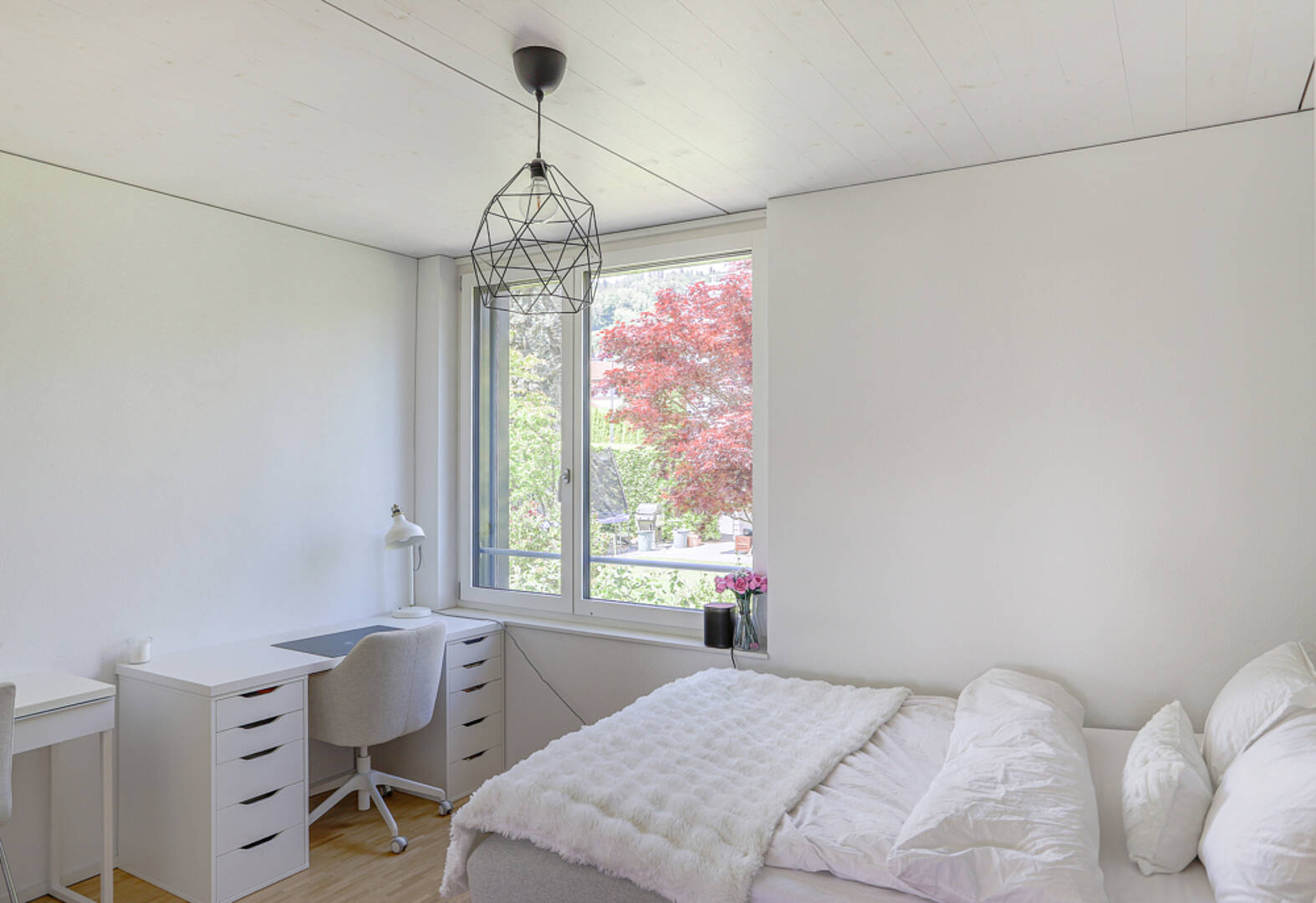 Helles Schlafzimmer mit Arbeitsplatz am Fenster