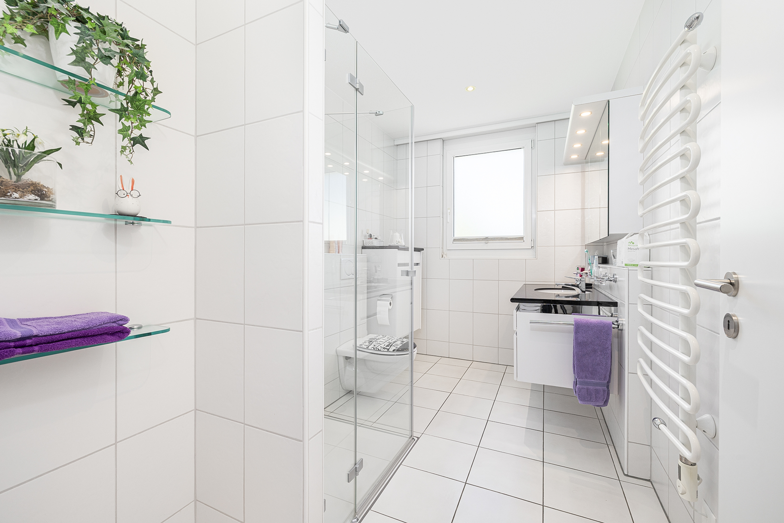 Modernes, helles Badezimmer mit Dusche und Fenster